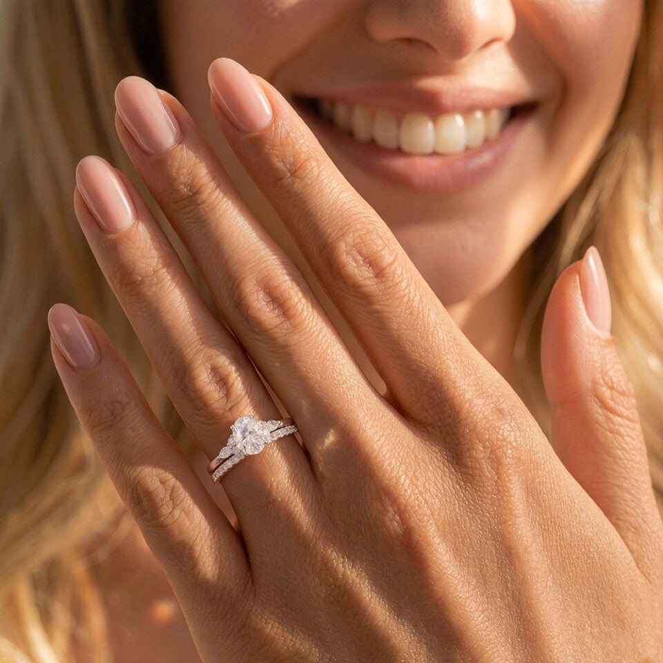 A Woman Wears a Oval Cut Moissanite Bridal Ring Set with Classic Straight Band