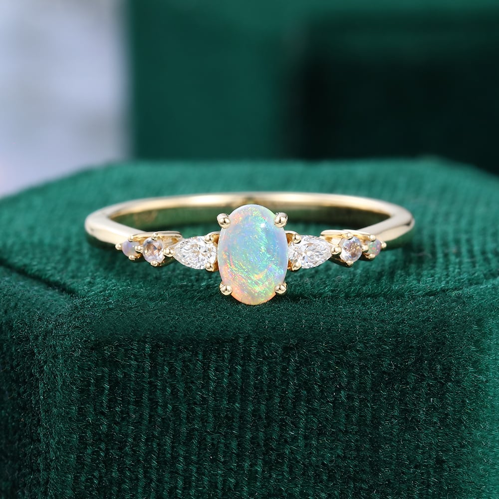 https://mollyjewelryus.com/wp-content/uploads/2023/04/Oval-Cut-4x6mm-Opal-Trio-Side-Stones-Dainty-Engagement-Ring-in-Yellow-Gold.jpg?utm_source=chatgpt.com