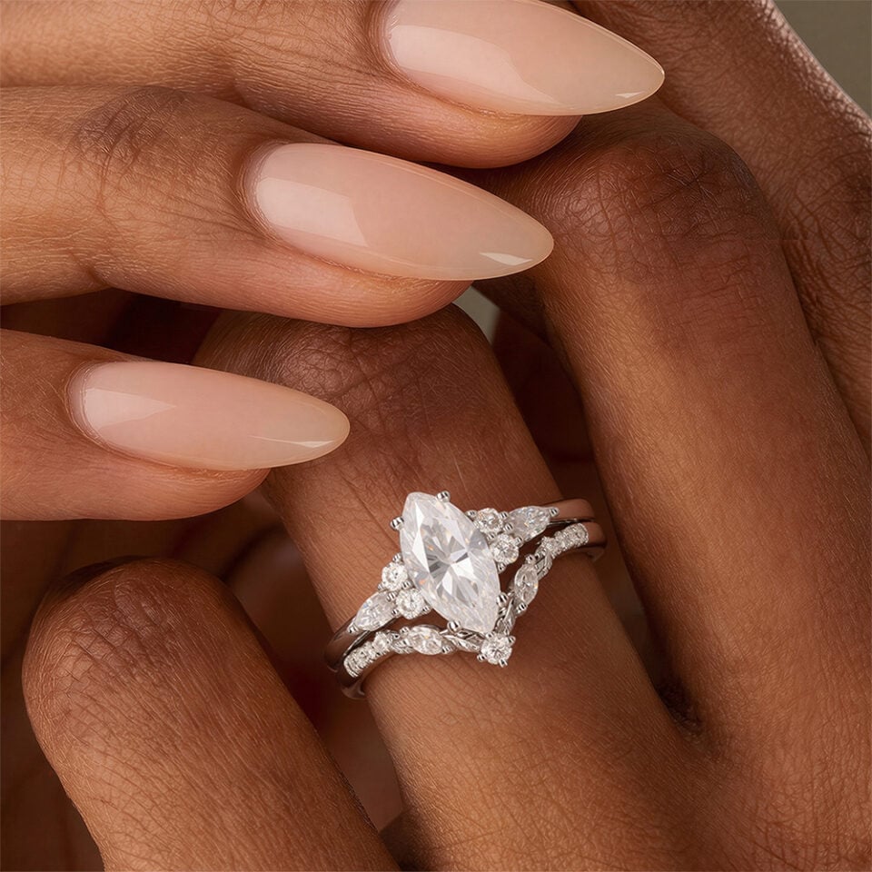 A Woman is Showing Off a Marquise Cut Moissanite Engagement Ring Set