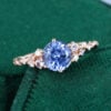 Round cut cornflower sapphire cluster engagement ring with twisted band