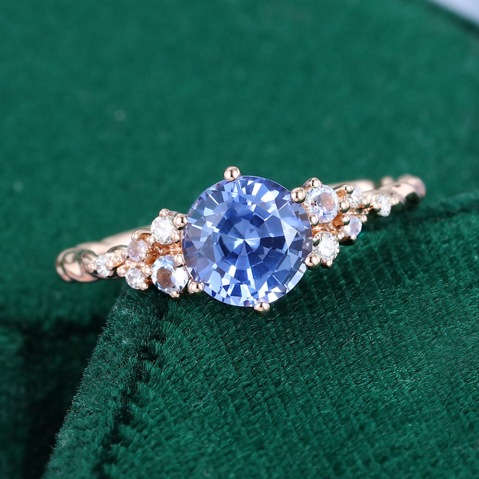 Round cut cornflower sapphire cluster engagement ring with twisted band