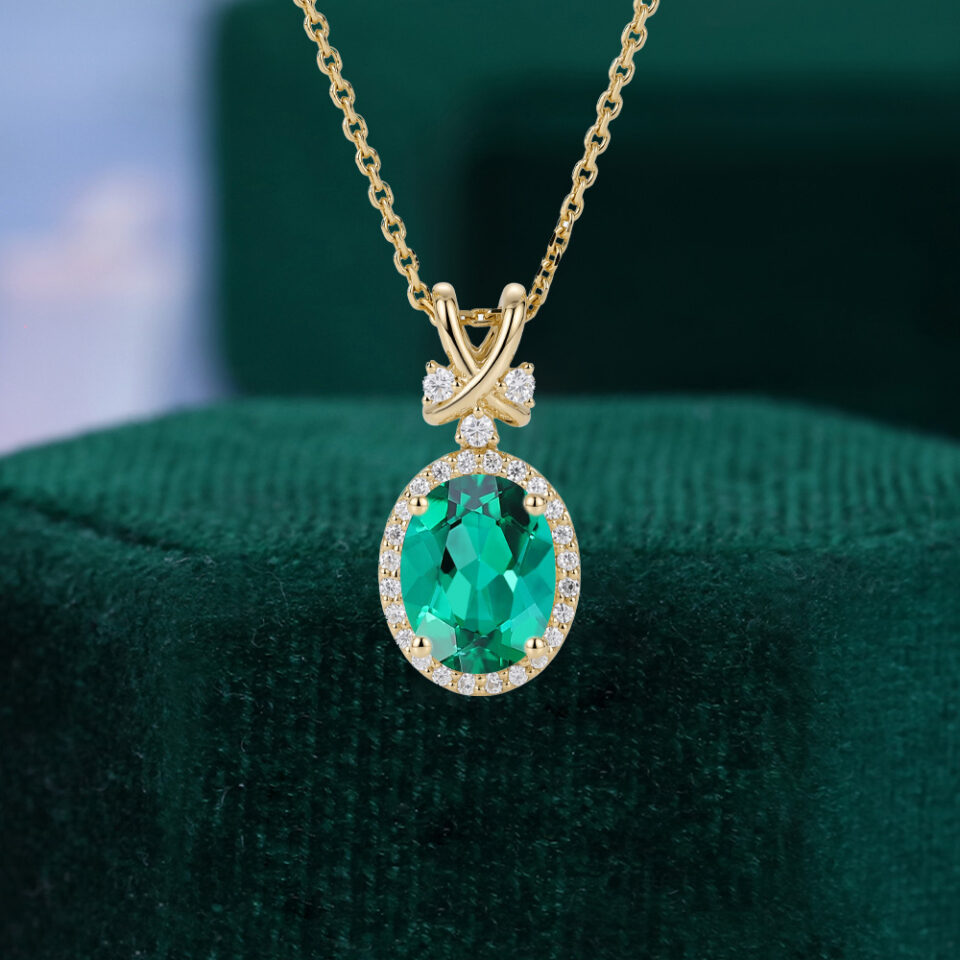 Oval cut emerald halo pendant necklace with criss cross accents